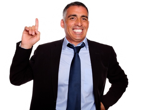 Portrait of a hispanic senior businessman pointing up against white backgroundの写真素材