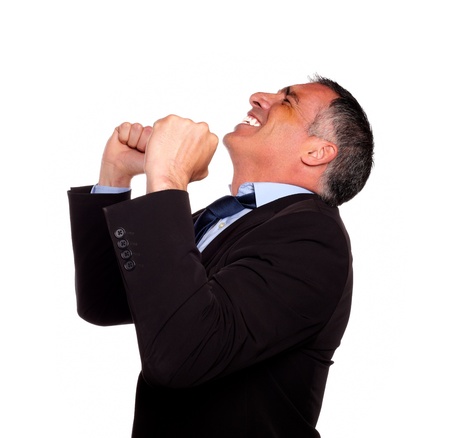 Portrait of a hispanic senior broker celebrating very happy a victory on isolated backgroundの写真素材