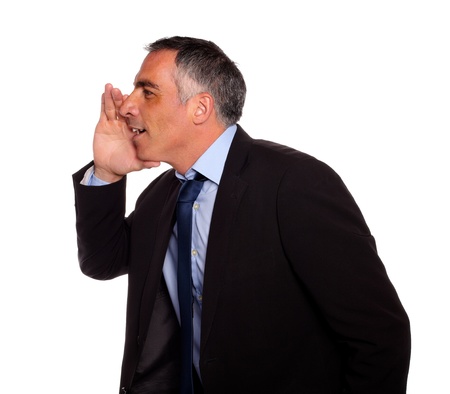 Portrait of a hispanic senior businessman on black suit whispering against white backgroundの写真素材