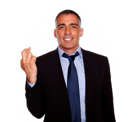 Portrait of a adult latin man crossing the fingers while wanting victory against white backgroundの写真素材