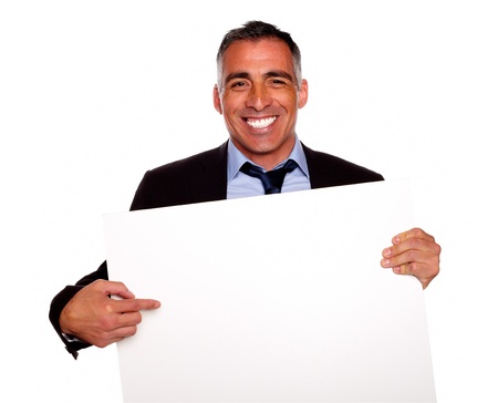 Portrait of a elegant executive man smiling and holding a white card with copyspace while having fun on isolated backgroundの写真素材