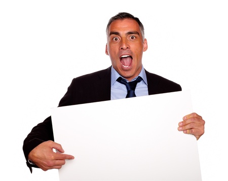 Portrait of a broker screaming, pointing and holding a white card with copyspace on isolated backgroundの写真素材