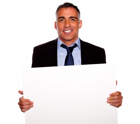 Portrait of a elegant businessman smiling and holding a white card with copyspace on isolated backgroundの写真素材