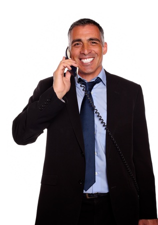 Portrait of a attractive broker laughing on phone on black and blue suit on isolated backgroundの写真素材