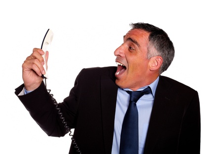 Portrait of a very stressed latin business man laughing with a phone against white backgroundの写真素材