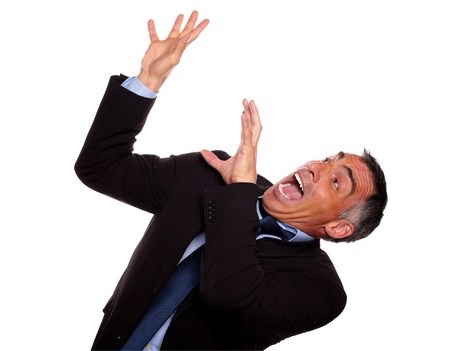 Portrait of a excited hispanic businessman screaming with hands up while falling down against white backgroundの写真素材