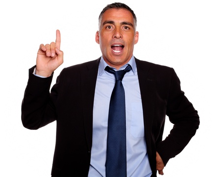 Portrait of a attractive executive speaking and pointing up on blue and black suit on isolated backgroundの写真素材