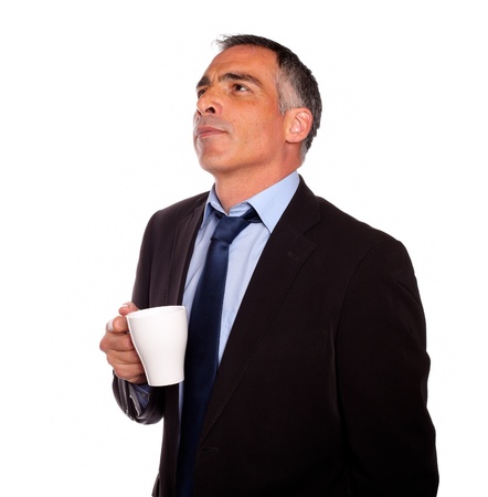 Portrait of a reflective business man with a white mug on isolated backgroundの写真素材