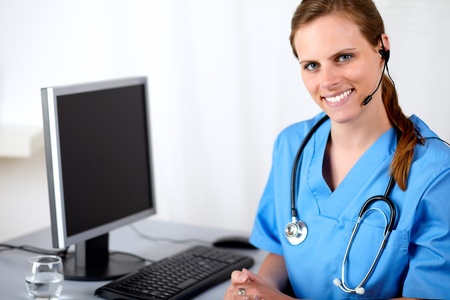 Portrait of a caucasian medical secretary smiling at hospital callcenterの写真素材