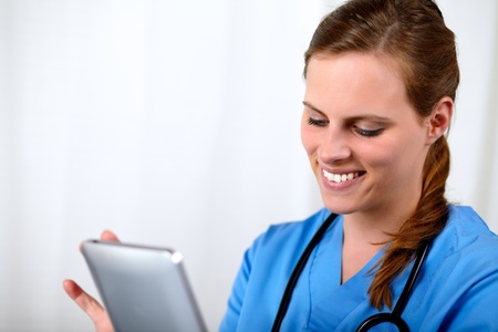 Close up portrait of a lovely charming doctor woman with a tablet PC at hospital officeの写真素材