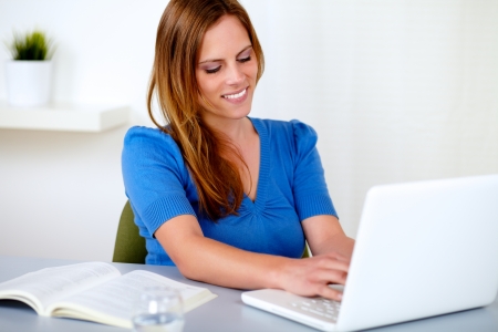 Portrait of a attractive blonde woman learning on laptop at home indoorの写真素材