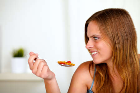 Portrait of a pretty blonde woman eating healthy food at home indoorの写真素材