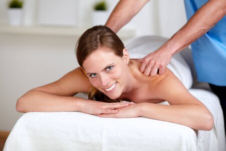 Portrait of a attractive woman receiving a body massage at a spa resortの写真素材