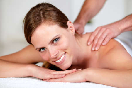 Close-up portrait of a young woman receiving a body massage at a spa resortの写真素材