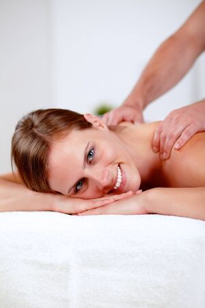 Close-up portrait of a young blonde girl relaxing at a spa while receiving a massage at spa resort with copyspaceの写真素材