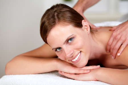 Portrait of a lovely pretty girl smiling and relaxing while getting a massage from a professional masseuse at spa - copy spaceの写真素材