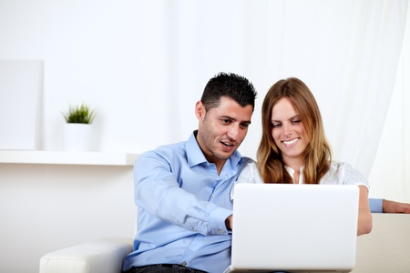 Portrait of a couple in love using a computer at home indoorの写真素材