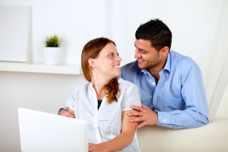 Portrait of a couple in love using a laptop together at homeの写真素材