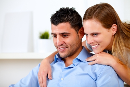 Portrait of a beautiful couple in love looking something at home indoorの写真素材