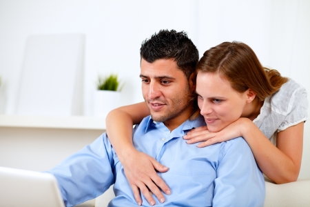 Portrait of a good looking couple using laptop together at home indoorの写真素材