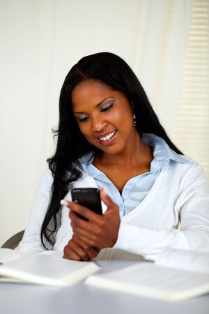 Portrait of a pretty young woman sending a sms with the mobile at soft colors compositionの写真素材