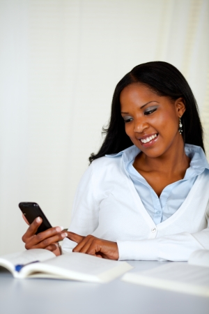 Portrait of a pretty young girl sending a sms with the mobile at soft colors compositionの写真素材