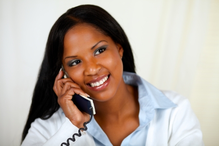 Close up portrait of an african woman conversing on phone at soft colors compositionの写真素材