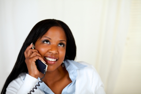 Close up portrait of a pretty woman smiling and conversing on phoneの写真素材