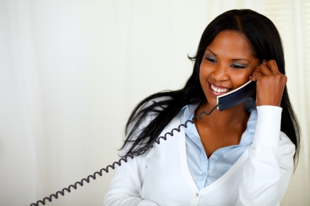 Portrait of a young lovely female laughing and conversing on phoneの写真素材