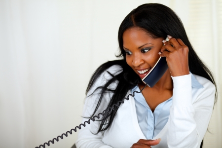 Portrait of a young impressed lovely girl conversing on phone at soft colors compositionの写真素材