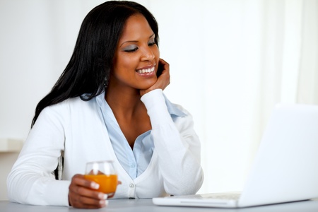 Portrait of an afro-american young woman looking to laptop screen  at soft colors compositionの写真素材
