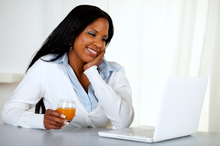 Portrait of a lovely student girl smiling and looking to laptop at soft colors compositionの写真素材