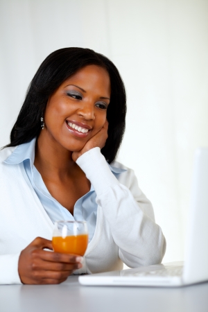 Portrait of a lovely student woman smiling and looking to laptop at soft colors compositionの写真素材