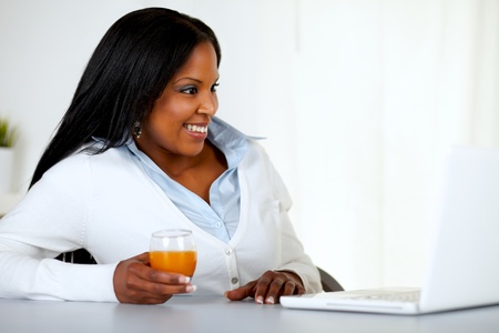 Portrait of a pretty young woman having fun on laptop screen at home indoorの写真素材