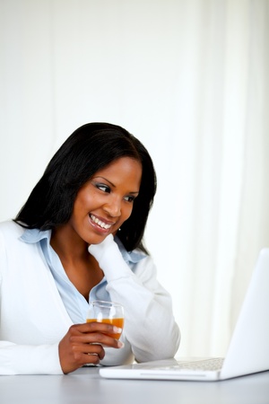 Portrait of a pretty relaxed female smiling and reading on laptop screen at soft compositionの写真素材