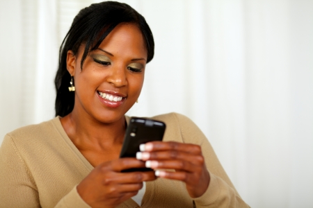 Portrait of an attractive young woman sending a text message with her mobile phoneの写真素材