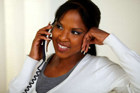 Portrait of a charming relaxed woman speaking on phone at soft colors compositionの写真素材