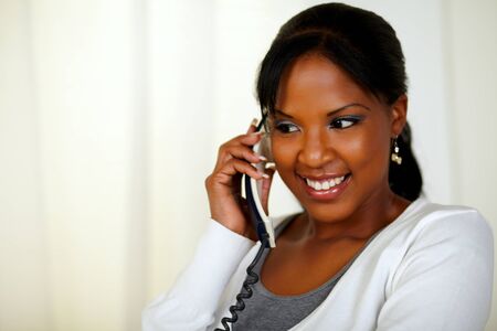 Portrait of a relaxed young woman conversing on phone at soft colors compositionの写真素材