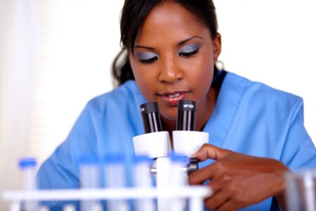 Young woman using a microscope at laboratory - portraitの写真素材