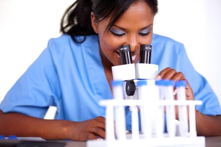 Charming scientific girl using a microscope at laboratoryの写真素材