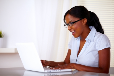 Attractive young woman with black glasses working on laptop at office - copyspaceの写真素材