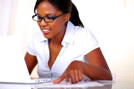 Afro-american female studying with laptop and documentsの写真素材