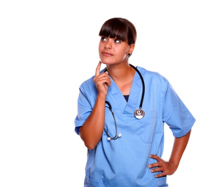 Portrait of a reflective nurse standing on blue uniform with a stethoscope on isolated background - copyspaceの写真素材