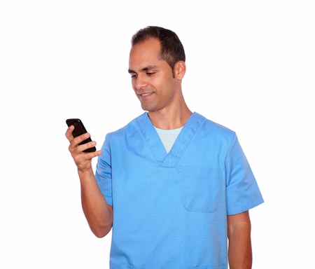 Portrait of a smiling male nurse sending message on cellphone on isolated backgroundの写真素材