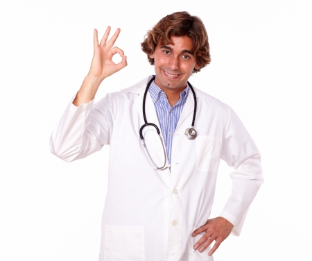 Portrait of a young latin medical practitioner showing positive finger gesture smiling directly at you, on isolated background.の写真素材