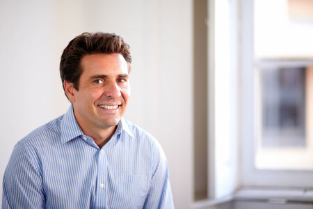 Portrait of a satisfied hispanic businessman smiling at you on closeup background - copyspace