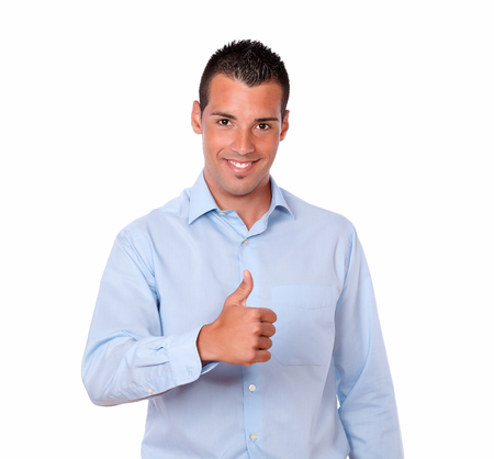 Portrait of a handsome young guy on blue shirt with ok sign standing and smiling at you on isolated studioの写真素材