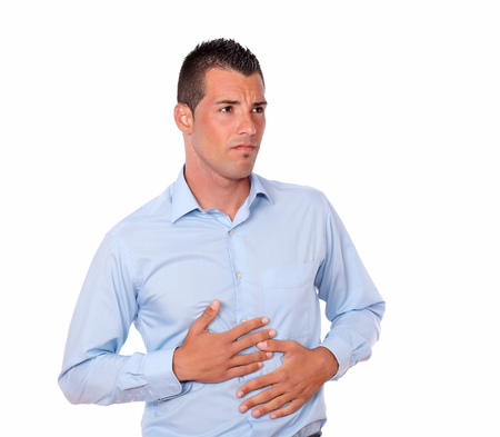 Portrait of an attractive young man on blue shirt with sick stomach standing and looking at you on...