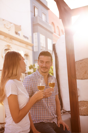 Handsome millenial couple enjoying some beers and each others company with the sun shining brightly behind themの写真素材