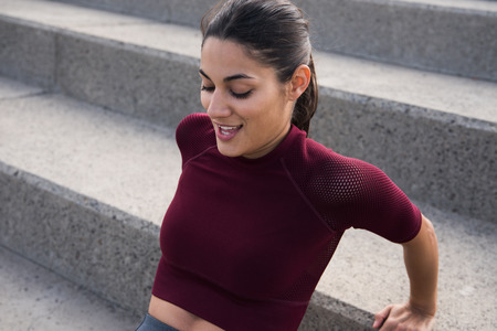 Attractive young brunette doing sports on stairs smiling with hair tied backの写真素材
